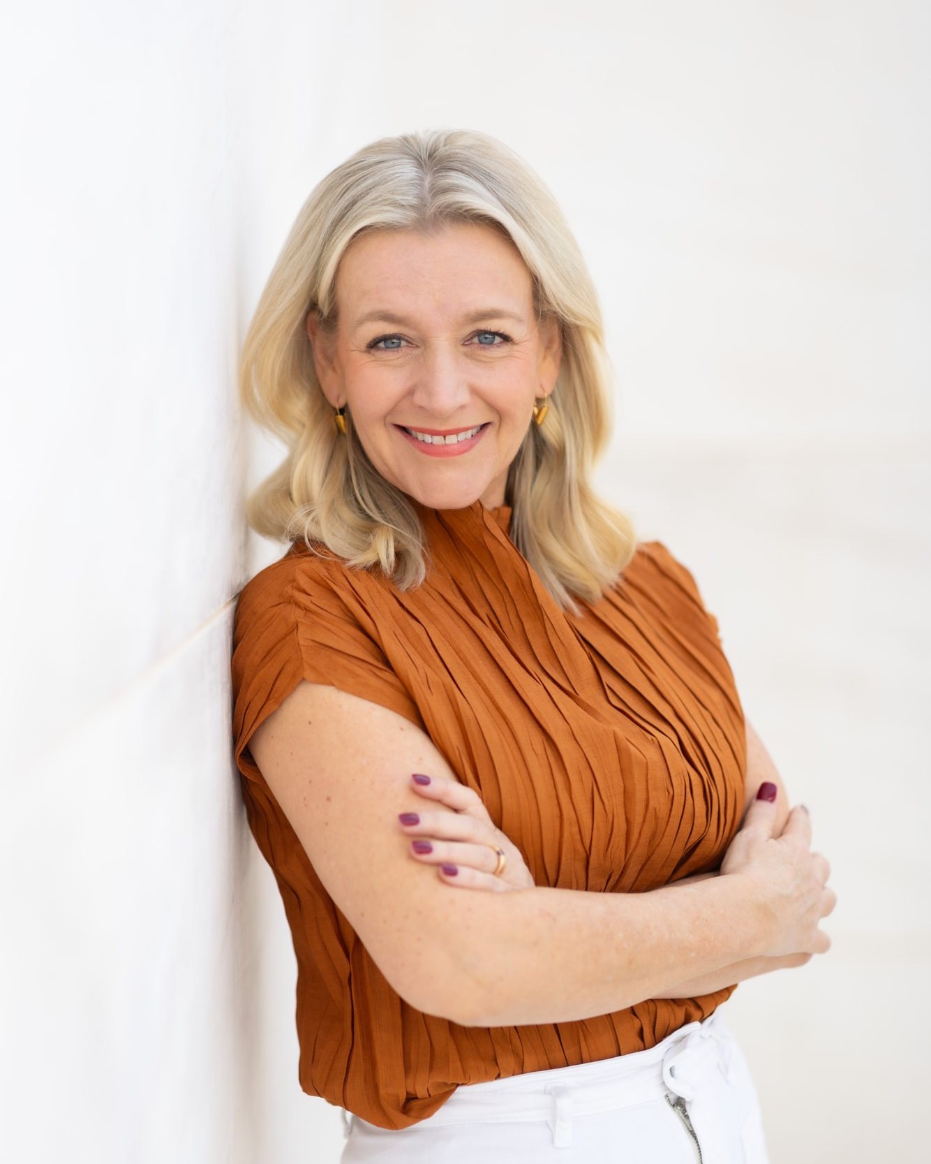 Cindy Hermsen, apoyada en una pared blanca, con los brazos cruzados